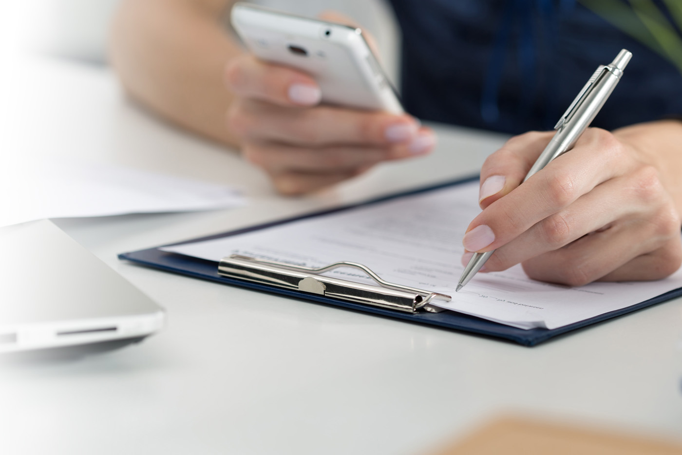 Une personne qui écrit sur un presse-papier